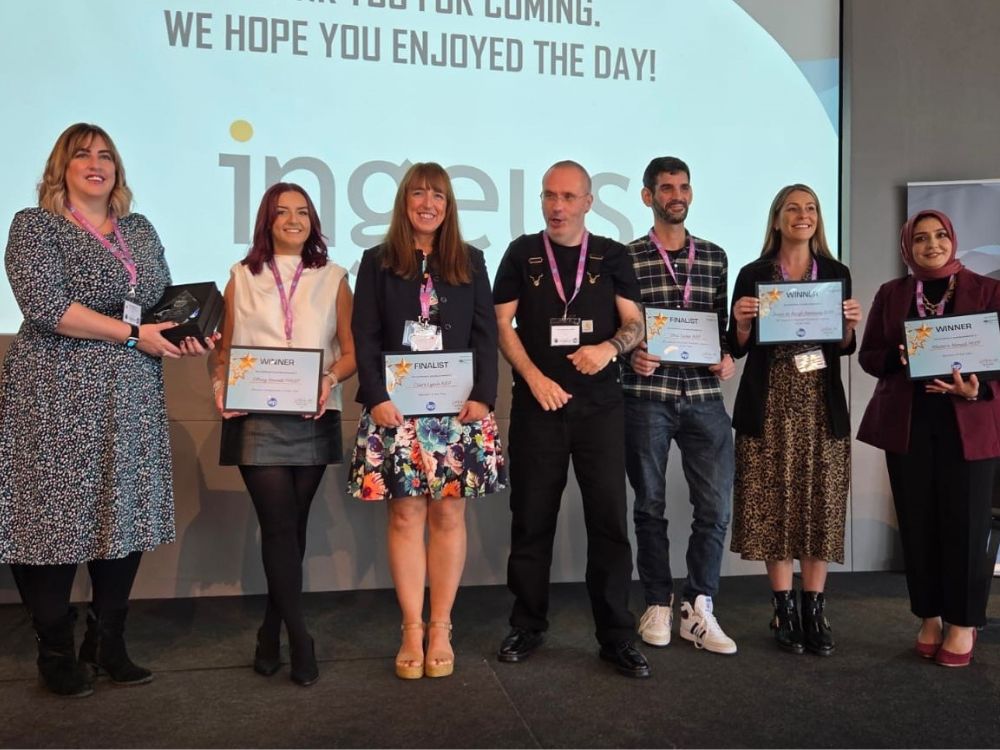 Claire Lynch an other finalists on stage holding award certificate