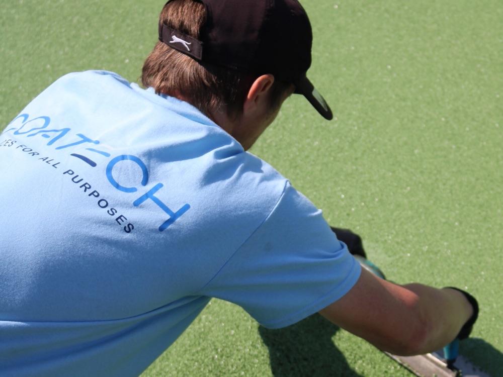 Man in branded tshirt and cap kneeling and working on the floor