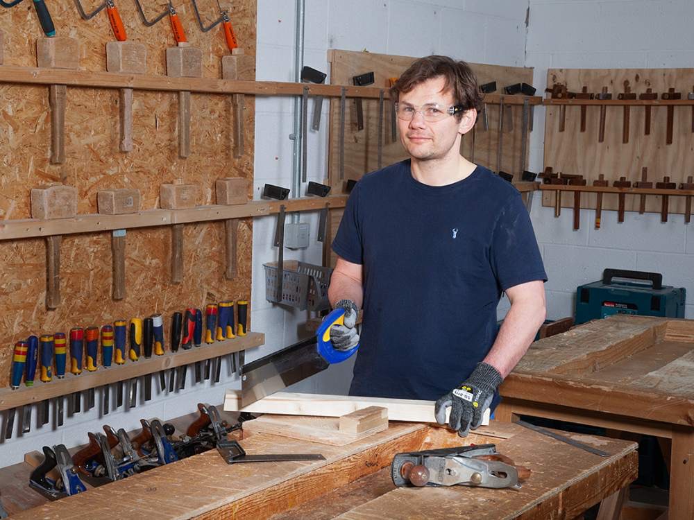 Young man doing woodwork in workshop