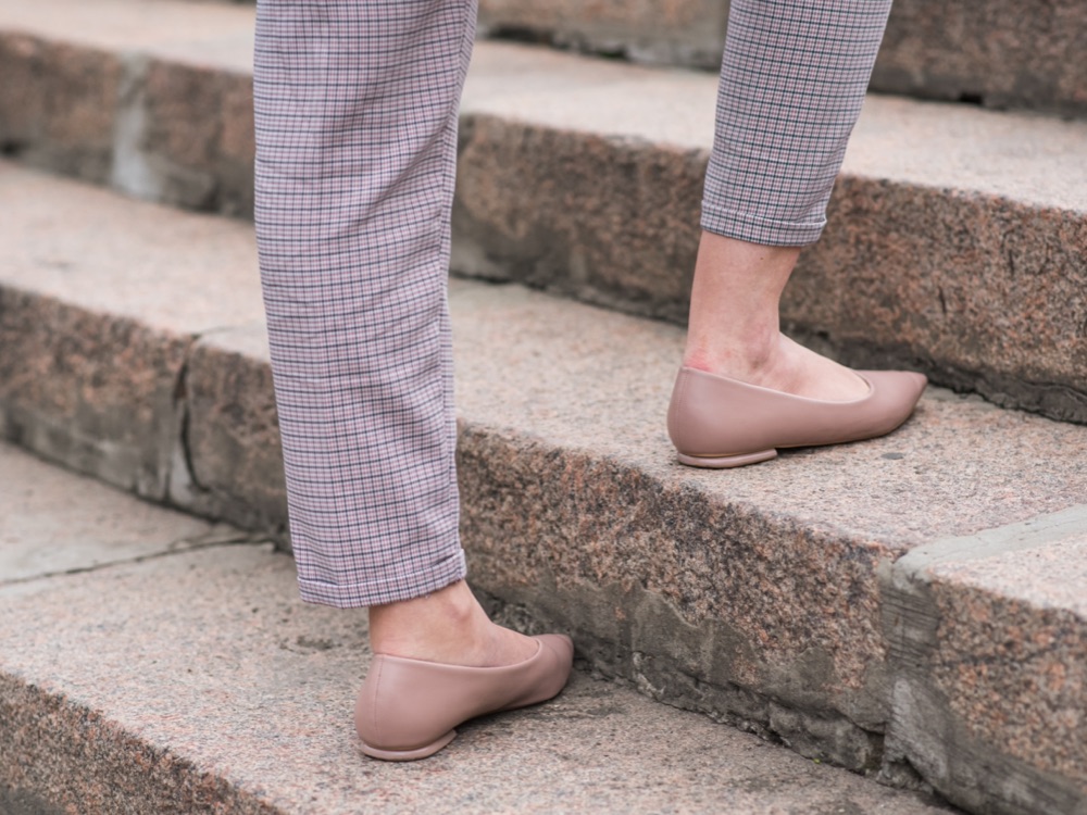 Mature woman's legs walking up stone steps