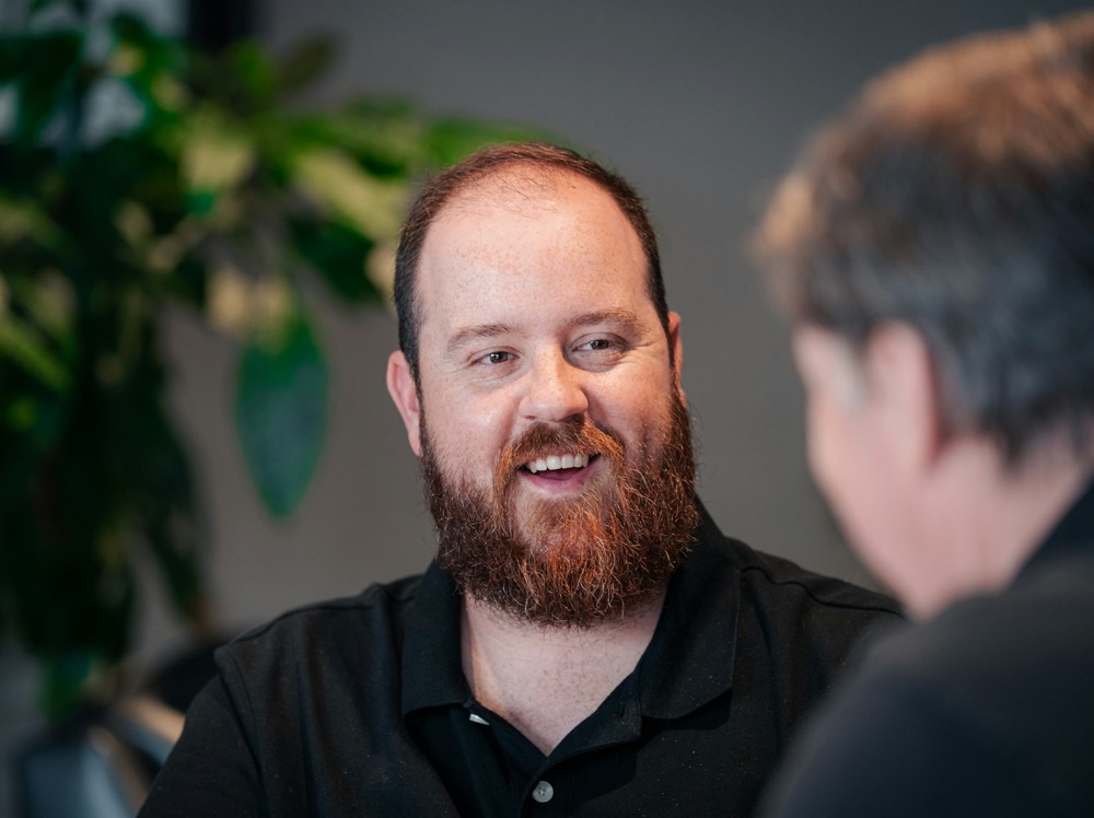 Two men smiling and talking at work