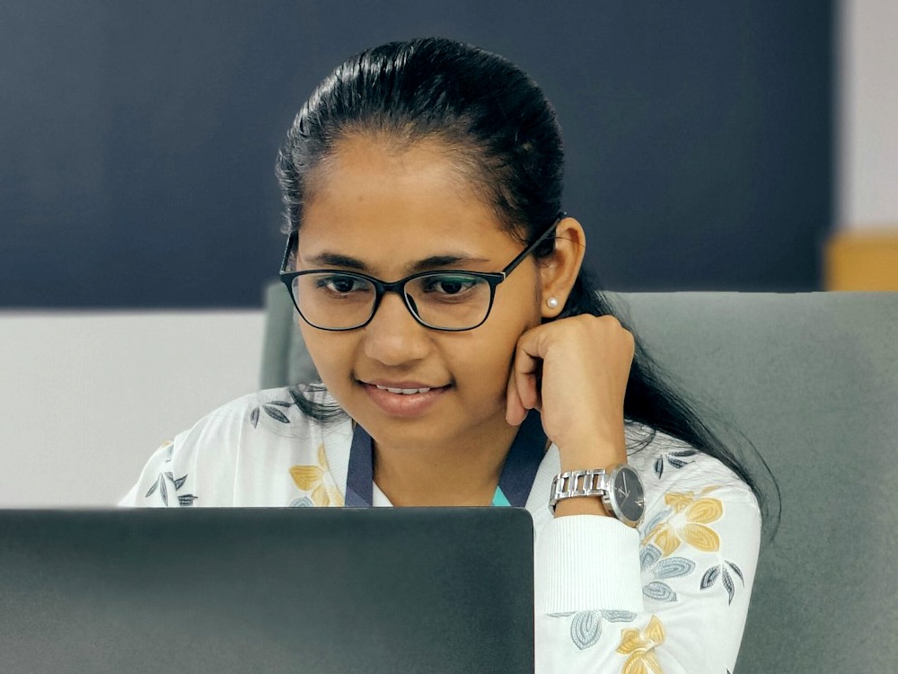 Young asian woman at work looking at laptop screen